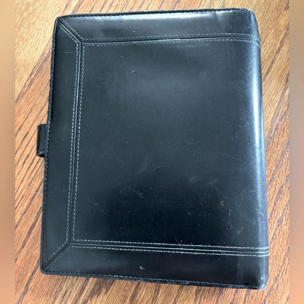 Black Leather (?) Day Timer Planner with Extra pages.